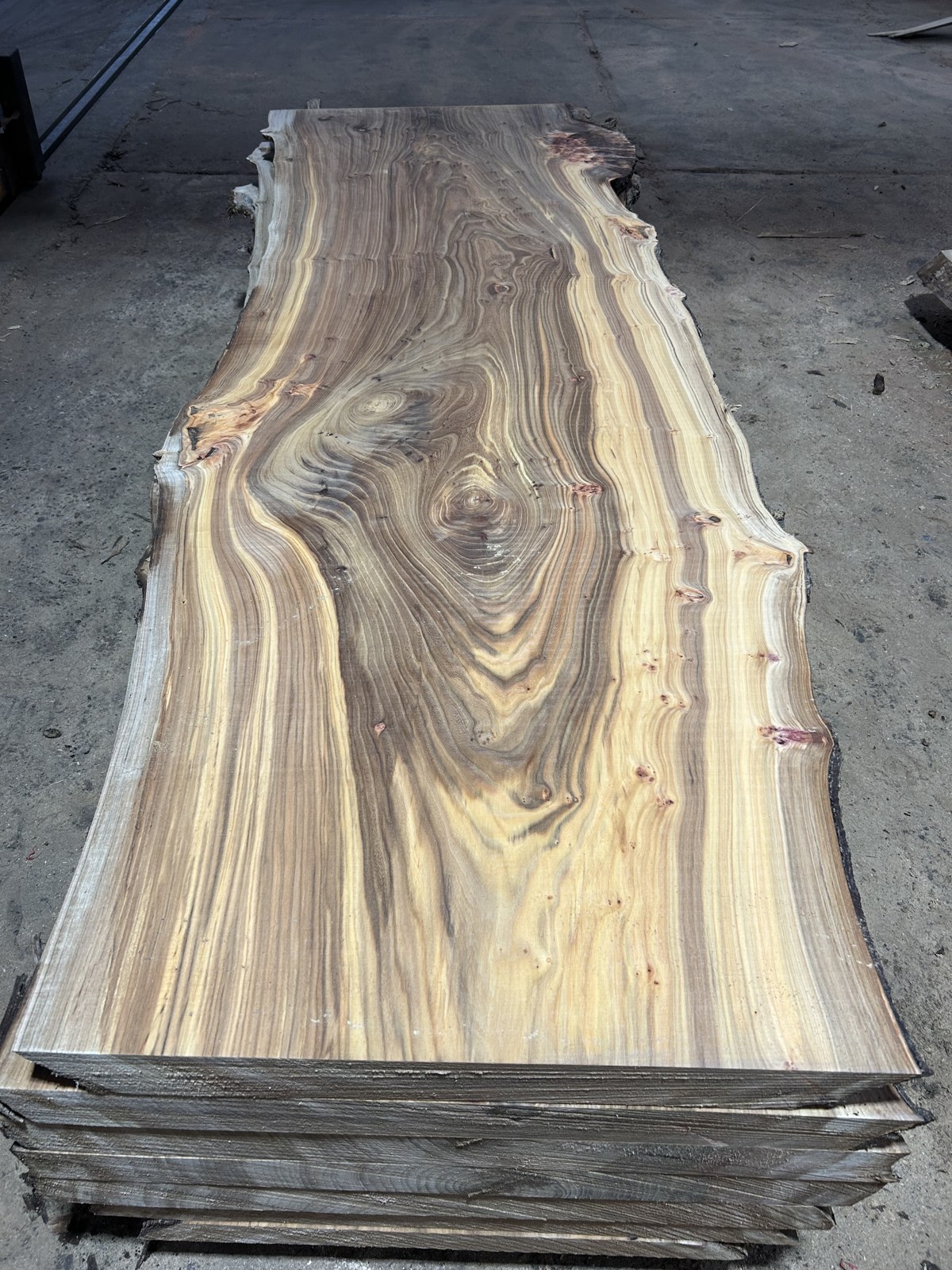 Tavola in legno massello con venature naturali marcate e bordo irregolare